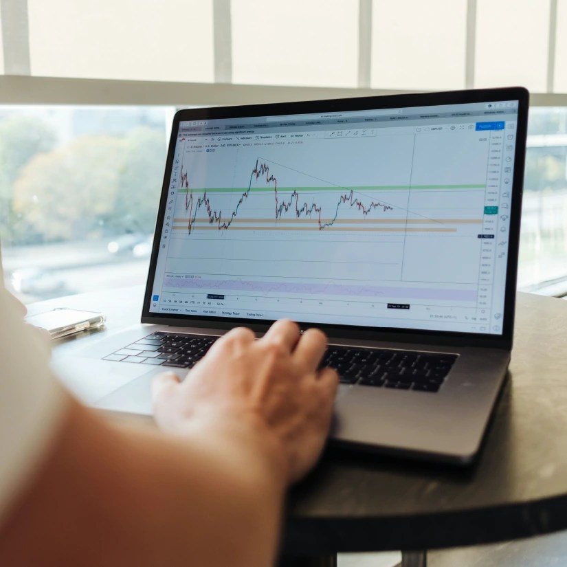 Someone typing on a computer with the screen showing graphs